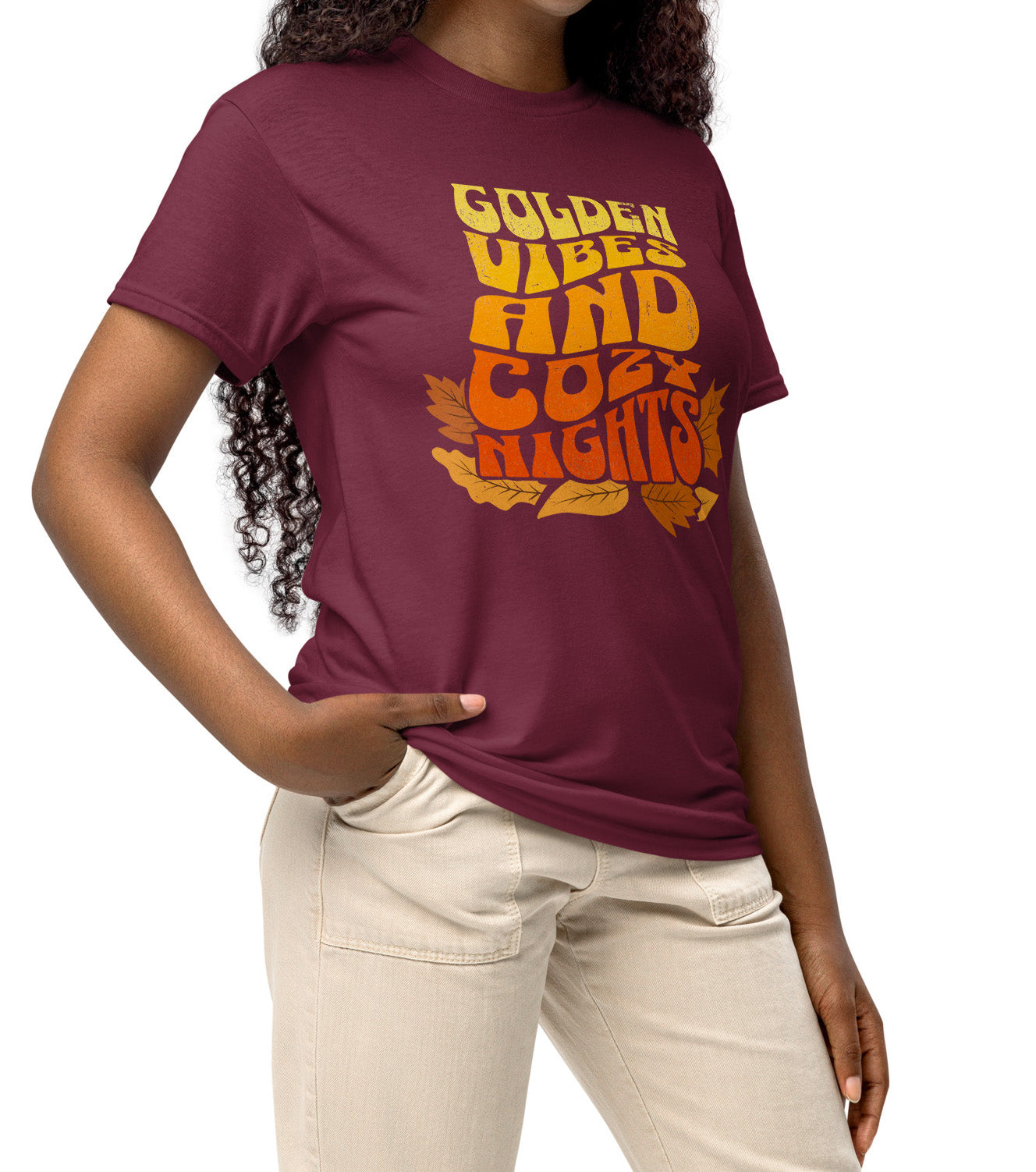 Comfy t-shirt with “Golden Vibes and Cozy Nights” text in yellow-to-orange gradient and autumn leafs, worn by a fall vibes fan BimBangDesign