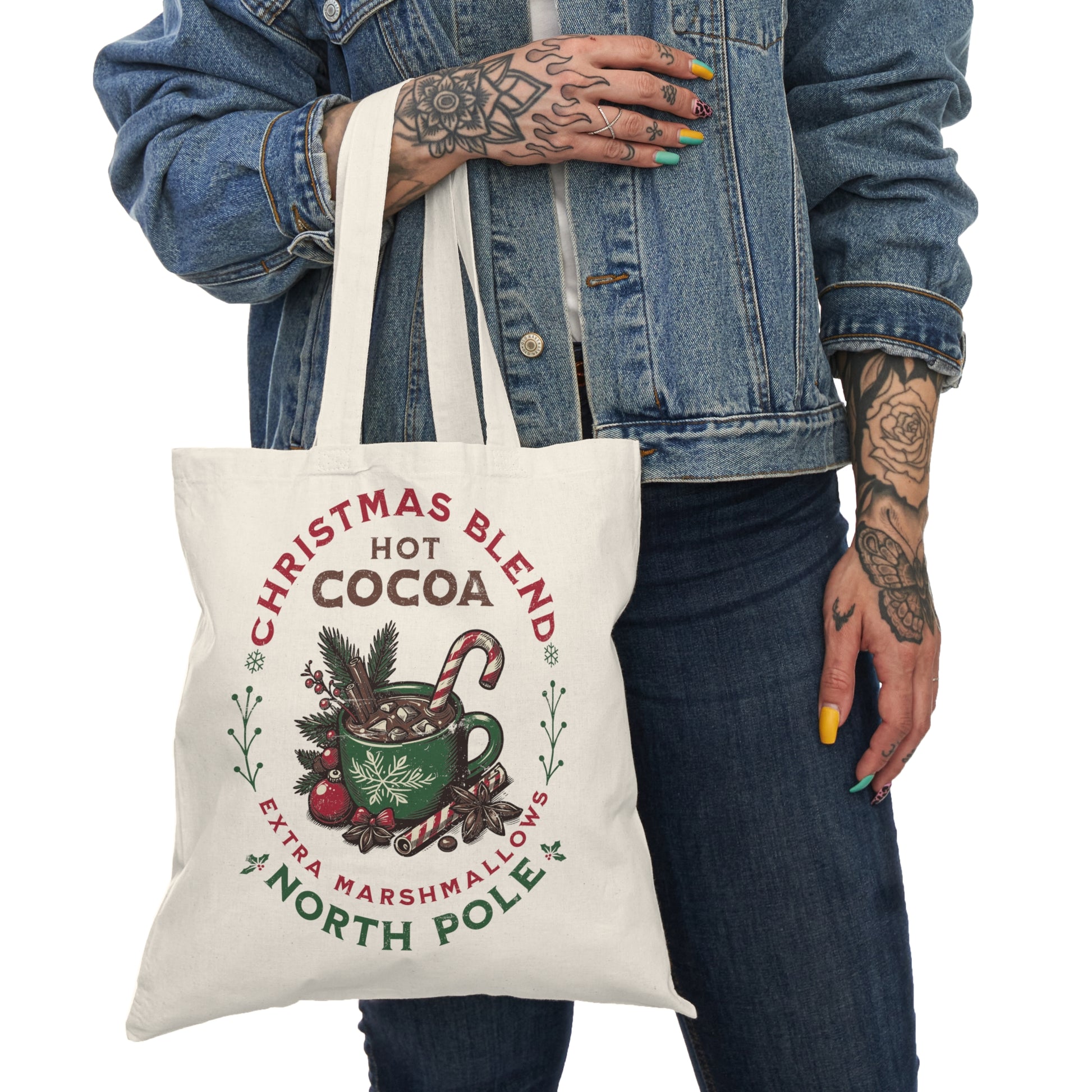 Eco-friendly Christmas tote bag featuring a cozy hot cocoa holiday design. Perfect for shopping, gift carrying, and festive outings. Held by a Christmas entousiast.