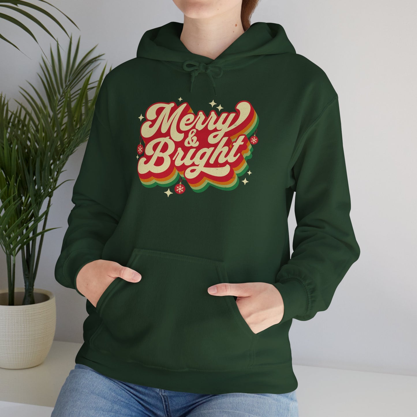 Cozy Unisex Christmas hoodie with warm fleece and festive “Merry & Bright” print worn by a Christmas entousiast BimBangDesign